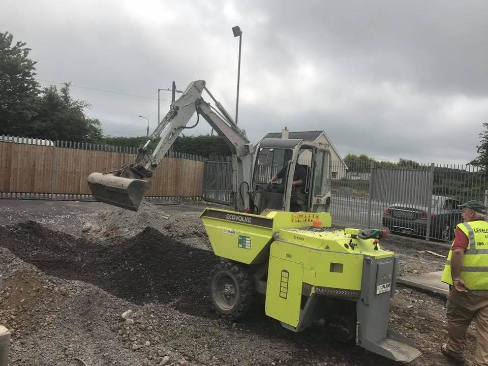 green electric dumper with digger on site